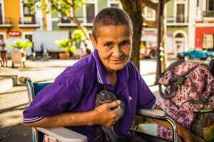woman wears purple polo shirt sitting on wheelchair